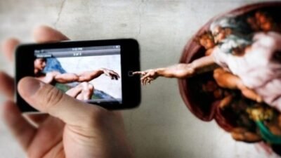 Gambar tersebut adalah perpaduan antara lukisan Allah karya Michaelangelo dan sebuah tangan yang sedang bermain gadget. Itulah fenomena religiusitas belakangan ini. Yang lebih parah lagi dalam kehidupan religious, yaitu imam, frater, suster, dan bruder. Untuk lebih medalami tema ini silakan simak tulisan “Religius, Medsos”